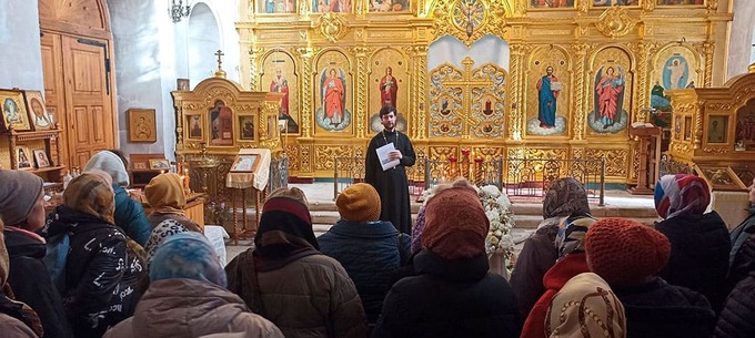 Отец Николай Ризниченко делится богатой историей Преображенского храма с внимающими паломниками.